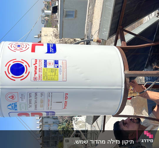 אדם מתקין דוד שמש על גג עם צינורות וחיבורים